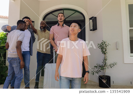 Friends arriving at house with luggage, excited for wedding celebration 135541909