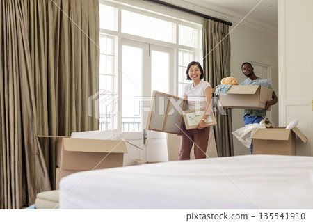 Couple unpacking boxes in new home, smiling and enjoying fresh start together Couple unpacking boxes in new home, smiling and enjoying fresh start together 135541910