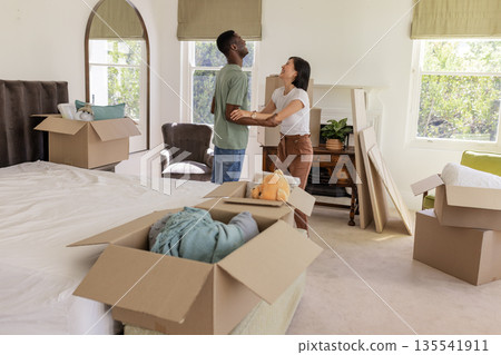 Couple unpacking boxes in new home, smiling and enjoying fresh start together 135541911
