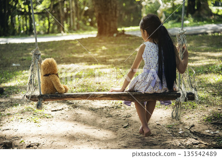 Happy Child hug teddy bear in green park playground. Teddy bear best friend for little kids cute girl. Autism happy funny playing together on playground in happiness family feel love and warm hugs 135542489
