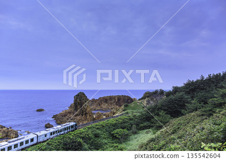 一列火車沿著藍色的海岸線和岩石景觀行駛 135542604