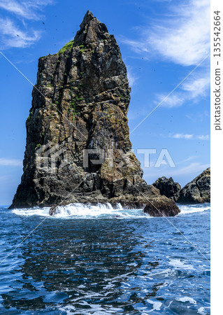 一塊巨大的岩石矗立在藍天碧海之中。 135542664