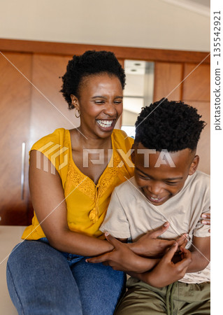 Mother and son laughing together at home, sharing joyful family moments Mother and son laughing together at home, sharing joyful family moments 135542921