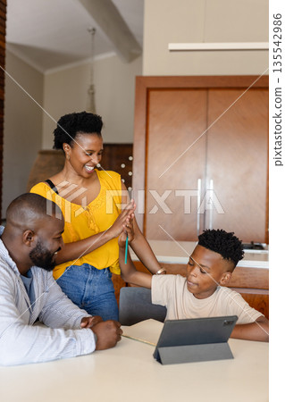 Family using tablet together at home, sharing smiles and laughter Family using tablet together at home, sharing smiles and laughter 135542986