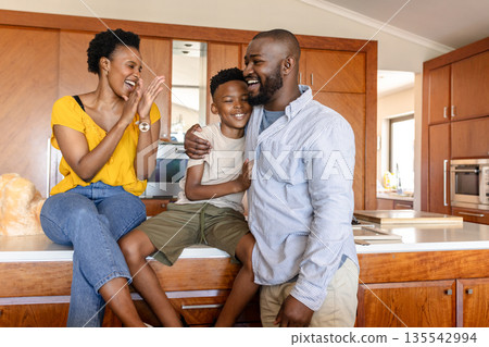 Happy family enjoying quality time together in modern kitchen, sharing laughter 135542994