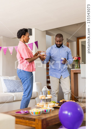 Celebrating at home, couple preparing snacks for festive family gathering 135543073