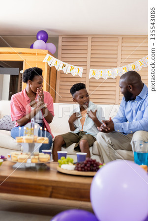Celebrating birthday, African American family enjoying cake and conversation at home Celebrating birthday, African American family enjoying cake and conversation at home 135543086