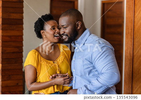 African American couple laughing and holding hands at home, enjoying quality time African American couple laughing and holding hands at home, enjoying quality time 135543096