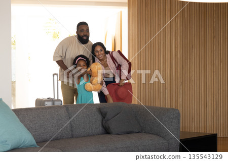 Happy family arriving at hotel room with luggage and teddy bear, smiling warmly Happy family arriving at hotel room with luggage and teddy bear, smiling warmly 135543129