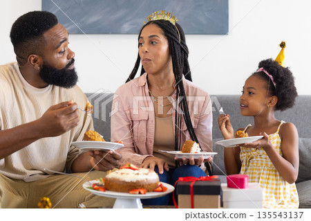 Celebrating birthday, happy family enjoying cake together on living room sofa 135543137