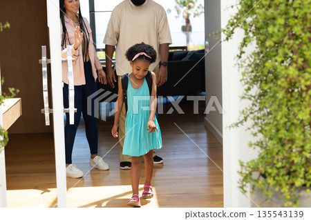 Family entering new home, young girl exploring living room with excitement Family entering new home, young girl exploring living room with excitement 135543139