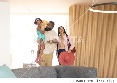 Happy family arriving at hotel, father holding daughter with teddy bear Happy family arriving at hotel, father holding daughter with teddy bear 135543144
