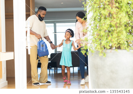 Preparing for school, parents holding child's hands, smiling together at home Preparing for school, parents holding child's hands, smiling together at home 135543145