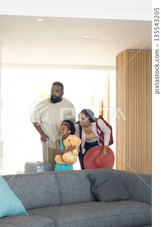 Family arriving home with luggage, smiling and excited after vacation 135543205