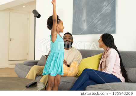Happy family enjoying quality time together on sofa at home, smiling and laughing Happy family enjoying quality time together on sofa at home, smiling and laughing 135543209