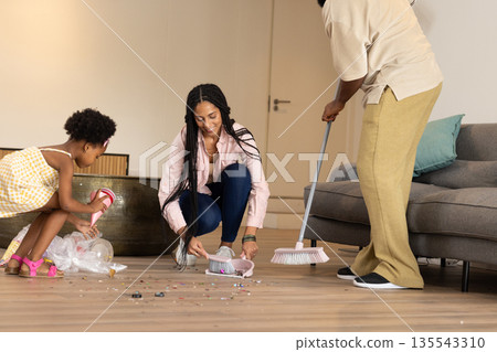 African American family cleaning living room floor together, enjoying quality time 135543310