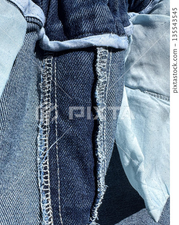 Close-up of blue denim fabric with detailed stitching. 135543545