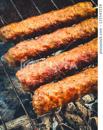 Grilled kebabs on skewers cooking over hot charcoal. 135543559