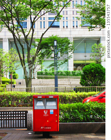 東京新宿區西新宿附近，郵筒、建築物和一輛紅色汽車的景色 135543757