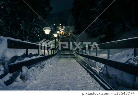 Night view with snowy stairs. Snow-covered staircase with illumi 135543774