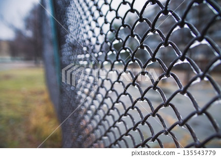 Metal mesh covered with ice close up. Deteriorating weather cond Metal mesh covered with ice close up. Deteriorating weather cond 135543779