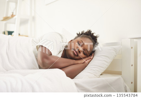 Young woman sleeping sweetly in cozy bedroom at modern home interior in the morning 135543784