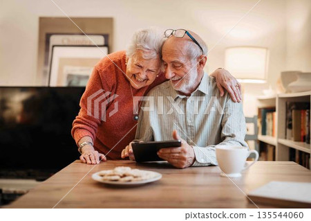 Elderly couple enjoying technology and spending time together. Elderly couple enjoying technology and spending time together. 135544060