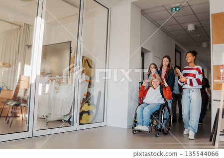 Teen students in school hallway, girl in wheelchair. Teen students in school hallway, girl in wheelchair. 135544066