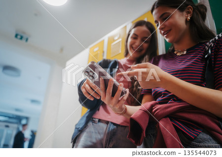 Teen students hanging out in school hallway by lockers. 135544073