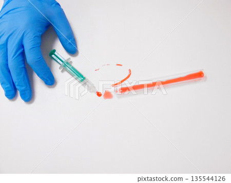 Blue Gloved Hand Approaching Green Syringe And Red Smear On White Surface, Safety Inspection And Contamination Blue Gloved Hand Approaching Green Syringe And Red Smear On White Surface, Safety Inspection And Contamination 135544126