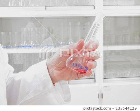 Laboratory Hand Manipulating Reagent Container, Careful Grip On Glassware, White Shelving Background, Laboratory Hand Manipulating Reagent Container, Careful Grip On Glassware, White Shelving Background, 135544129
