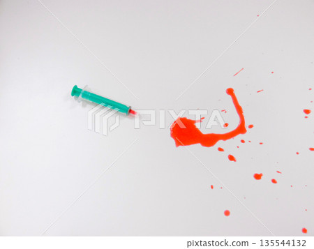 Single Syringe Beside Vivid Red Spill On White Surface, Glossy Liquid Forming Irregular Stain, Green Syringe Single Syringe Beside Vivid Red Spill On White Surface, Glossy Liquid Forming Irregular Stain, Green Syringe 135544132