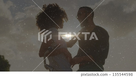 Standing pregnant woman in striped dress and man touching belly at sunset, with bicycle lens flare 135544598