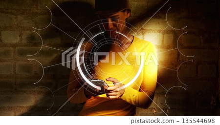 Using smartphone, woman in yellow shirt, dark cap viewing AR overlay against exposed brick wall Using smartphone, woman in yellow shirt, dark cap viewing AR overlay against exposed brick wall 135544698