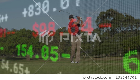 Golfer wearing striped polo swinging on fairway, with club, ball, glove and market ticker overlay 135544701