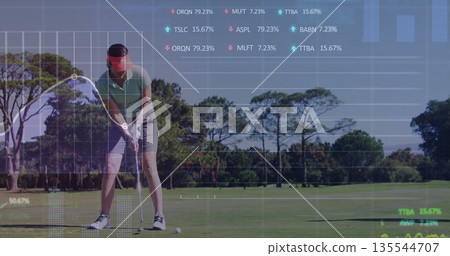 Bending adult golfer wearing visor teeing ball from tee with club on fairway with data overlays 135544707
