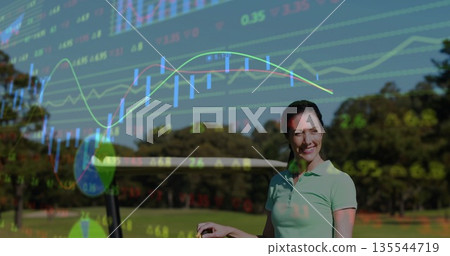 Standing woman wearing polo shirt holding club on fairway, with financial data overlays, copy space 135544719