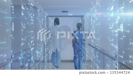 Two staff in scrubs and coat walking toward door in hospital corridor with holographic data streams 135544724