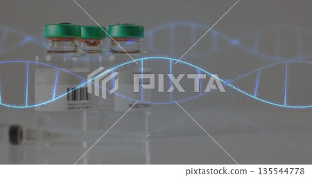 Showing three injection vials with green caps sitting on lab countertop, with syringe and DNA helix 135544778