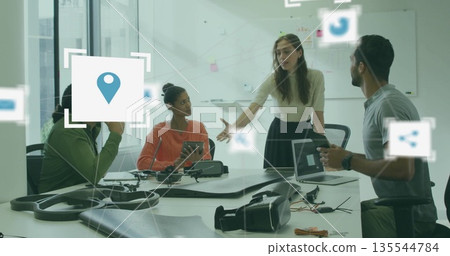 Gesturing designer presenting prototype in design studio, with drone frame and VR headset 135544784