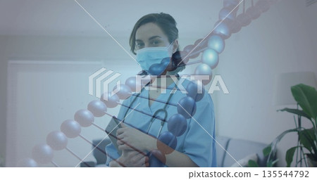 Holding tablet, female nurse with stethoscope examining DNA data in clinic, with DNA overlay 135544792