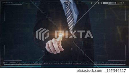 Pointing businessman wearing dark suit and tie, activating touchpoint in control room with grid 135544817