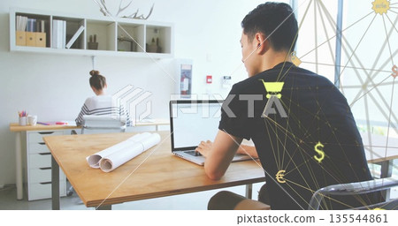 Asian man typing on laptop in office with blueprints, pencils and digital overlay, copy space Asian man typing on laptop in office with blueprints, pencils and digital overlay, copy space 135544861