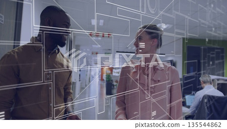 Walking business casual colleagues discussing interface design in hallway with wireframe diagrams Walking business casual colleagues discussing interface design in hallway with wireframe diagrams 135544862