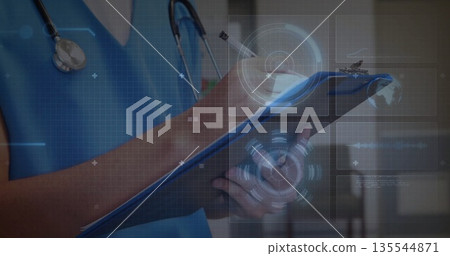 Doctor in blue scrubs and stethoscope scanning tablet with stylus in corridor, with holographic UI Doctor in blue scrubs and stethoscope scanning tablet with stylus in corridor, with holographic UI 135544871