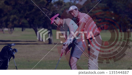 Guiding golf instructor positioning mature woman adjusting swing on fairway, with golf club 135544887
