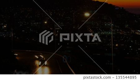 Driving two cars down hillside road at dusk, with headlights, streetlamp, guardrail, copy space Driving two cars down hillside road at dusk, with headlights, streetlamp, guardrail, copy space 135544895