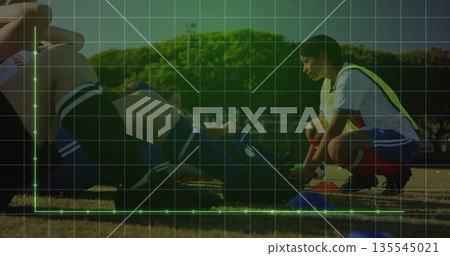 Soccer player wearing yellow bib tying cleats on grass field, with blue training cones, copy space Soccer player wearing yellow bib tying cleats on grass field, with blue training cones, copy space 135545021