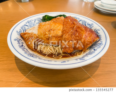 Fried noodles topped with grilled steamed chicken. Fried noodles topped with grilled steamed chicken. 135545277
