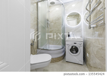 Interior of a small bathroom with glass shower and marble tiles 135545424